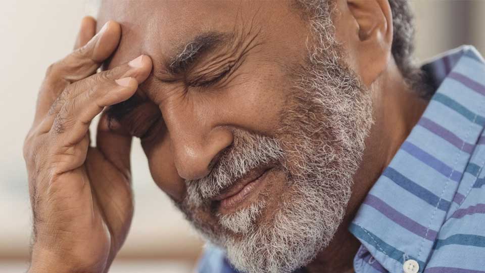 Homme touchant son oreille, indiquant une gêne auditive ou des acouphènes