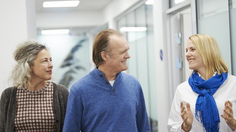 Un couple avec une audioprothésiste discutant du suivi en santé auditive.