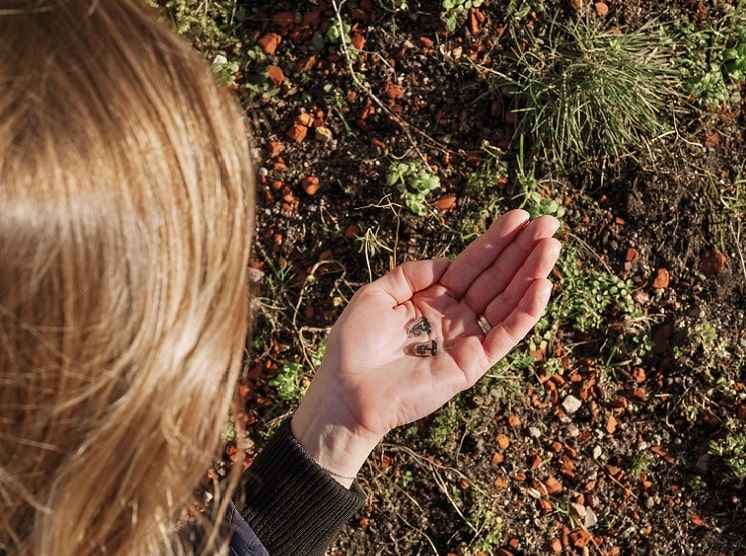 Une femme tient des appareils auditifs intra-auriculaires dans sa main