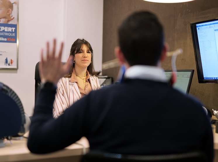Un professionnel de l’audition réalisant un test auditif dans un cabinet équipé.
