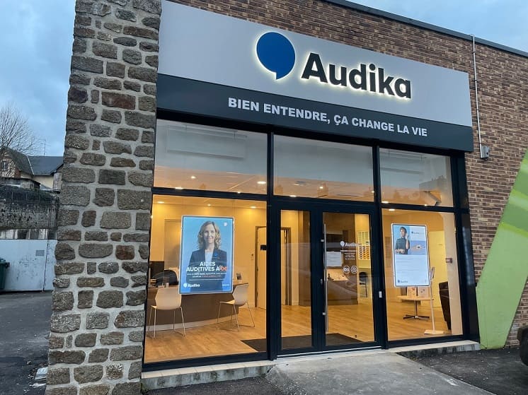Façade du centre Audika La Ferté-Macé avec enseigne et vitrines éclairées.