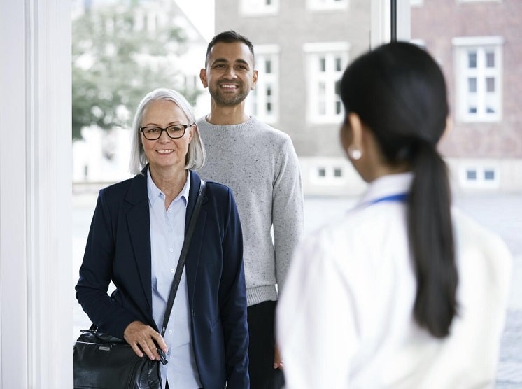 Une femme âgée accompagnée d’un proche arrivant pour une consultation dans un centre Audika.