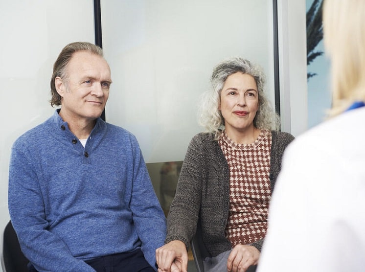 Un couple en rendez-vous en centre audika avec un audioprothésiste pour son suivi des appareils auditifs