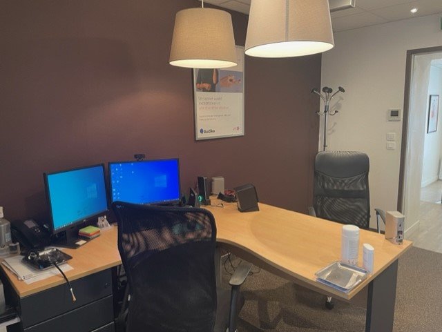 Cabinet moderne d’audioprothésiste à Bourg-en-Bresse, équipé de bureaux, chaises ergonomiques et matériel informatique.