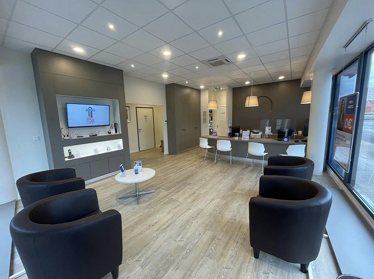 Salle moderne et lumineuse du centre auditif de Dijon avec espaces d’accueil et mobilier confortable.
