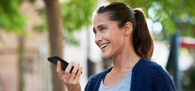 Jeune femme utilisant un smartphone en extérieur.