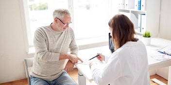 Un patient en rendez-vous avec un audioprothésiste pour faire un choix sur son appareil auditif