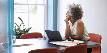 personne pensive regardant par la fenêtre avec des appareils auditifs