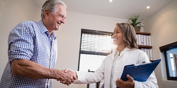 Audioprothésiste serrant la main d'un client heureux