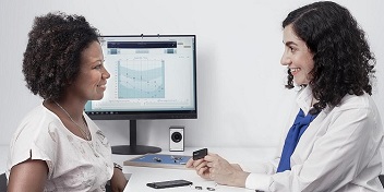 audioprothésiste présentant un audiogramme à une patiente dans un cabinet médical