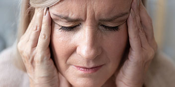 Femme pressant ses tempes avec ses mains