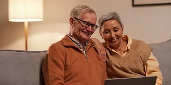 Un couple de retraité regarde la tablette