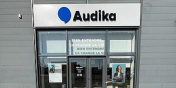 Façade du centre Audika Avignon Vedène avec affiches promotionnelles et logo blanc et bleu.