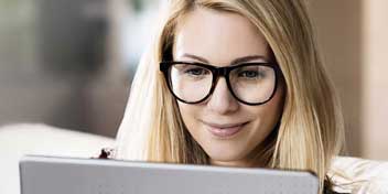 Femme utilisant un ordinateur portable, portant un appareil auditif.