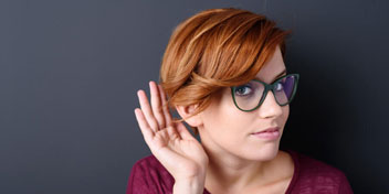 Jeune femme met la main à son oreille