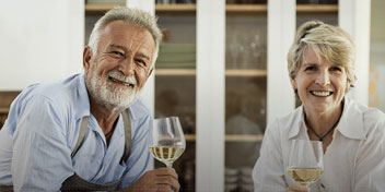 Couple de seniors dégustant un verre de vin blanc ensemble