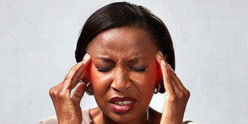 Femme touchant ses tempes, souffrant d'acouphènes