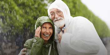 Un couple portant des aides auditives profite d’une randonnée sous la pluie