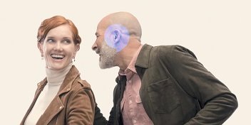 Deux personnes portant des aides auditives partageant un moment de complicité