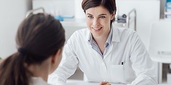 Un audioprothésiste en consultation avec une jeune femme pour un bilan auditif.