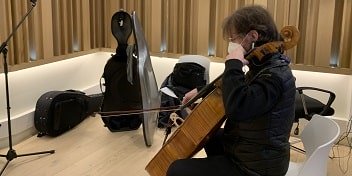un violoncelliste jouant du violoncelle dans une cabine de musique