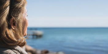 Femme méditant en regardant l’océan calme