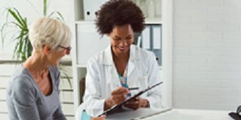 Une audioprothésiste explique des options de soins auditifs à une patiente dans un centre Audika