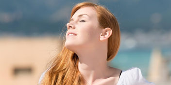 Femme aux cheveux roux appréciant le soleil en plein air