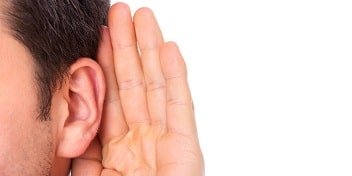 Un homme plaçant sa main derrière son oreille pour mieux entendre