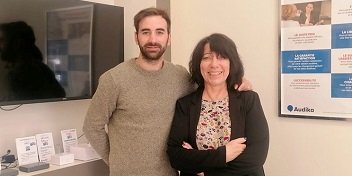 Audioprothésistes Audika à Toulouse, quartier des Minimes, posant dans un bureau avec affiches d’information et présentoirs.