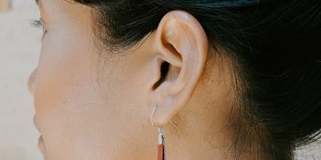 Vue rapprochée sur l'oreille d'une personne portant une boucle d'oreille.