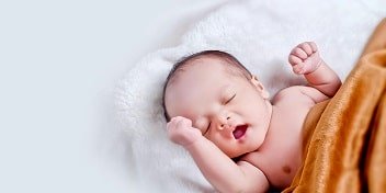 Un bebé tumbado en una cama