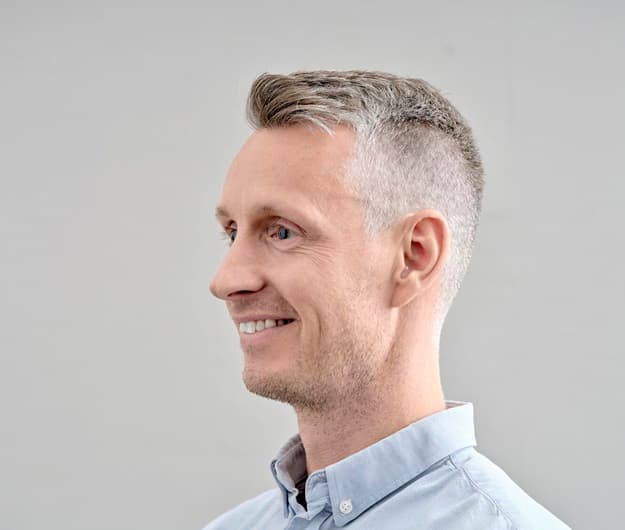 Monsieur porte un appareil auditif invisible dans l'oreille