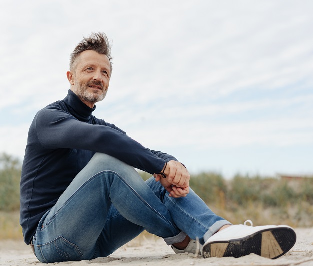 Un homme assis en tailleur dans la nature