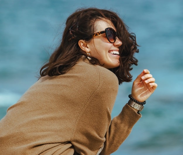 Une femme avec des lunettes de soleil en bord de mer