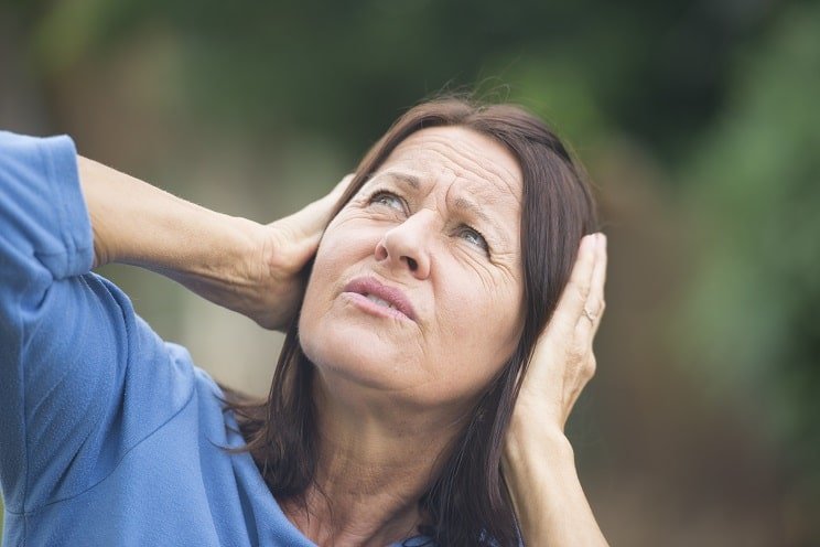 Femme souffrant d'inconfort auditif en se couvrant les oreilles avec les mains