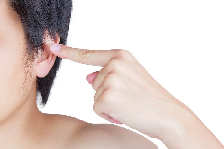 Homme pointant son oreille avec un doigt