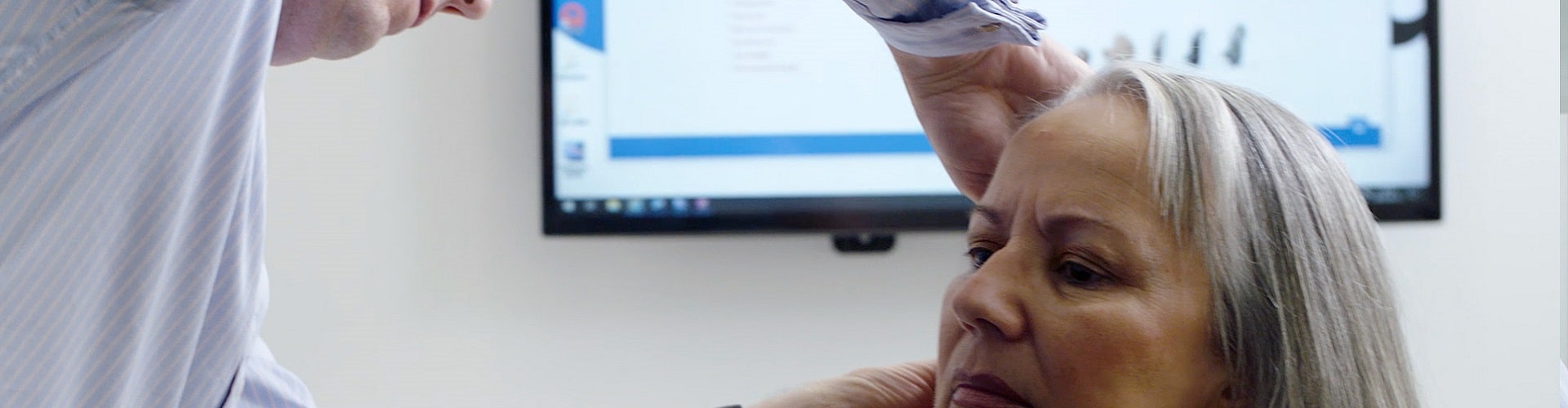 Audioprothésiste examinant l'audition d'une femme âgée dans un cabinet médical