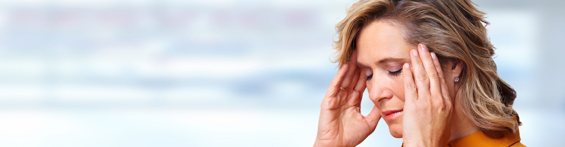 Femme souffrant de surdité brusque se tenant la tête