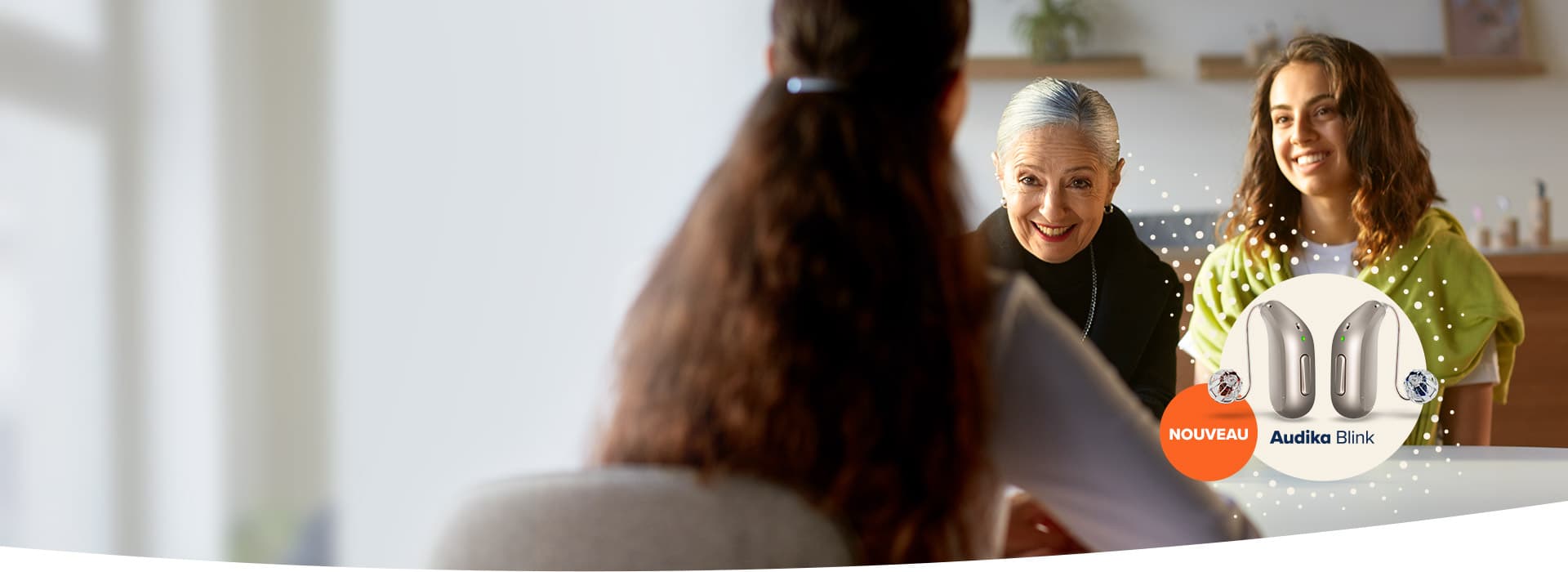 Consultation d’une femme et de sa fille chez un audioprothésiste pour découvrir les appareils auditifs Audika Blink.