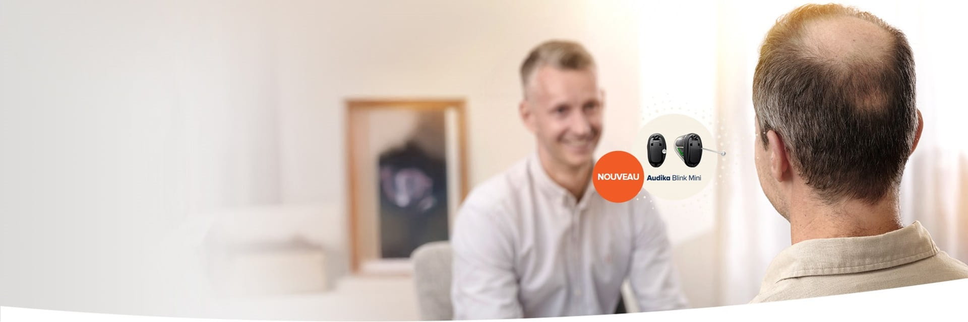 Audioprothésiste en consultation avec un patient portant des appareils auditifs Audika Blink Mini.