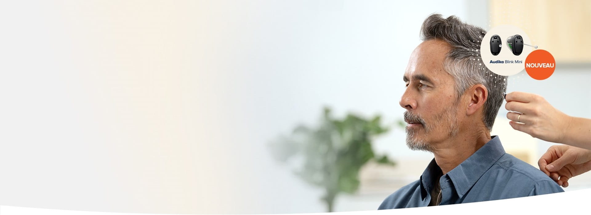 Personne malentendante testant Audika Blink Mini, nouveau modèle d’aide auditive.
