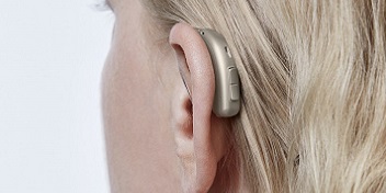 aide auditive derrière l'oreille d'une femme blonde