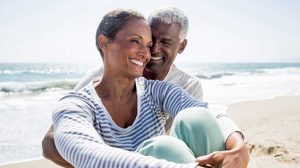 Couple senior profitant d'un moment détendu sur la plage avec vue sur la mer
