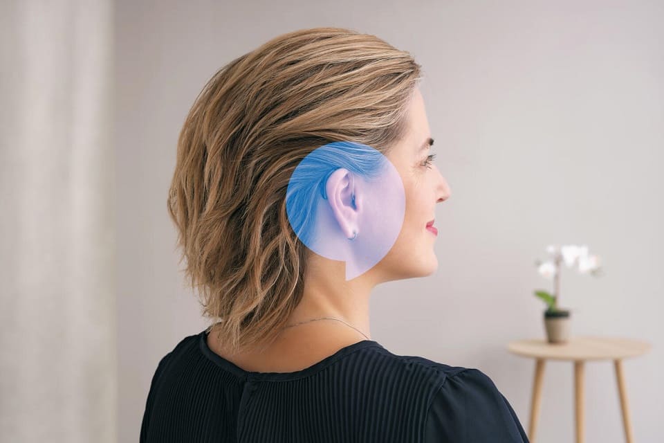 Femme portant des appareils auditifs 100% Santé avec effet de mise en avant autour de l’oreille.