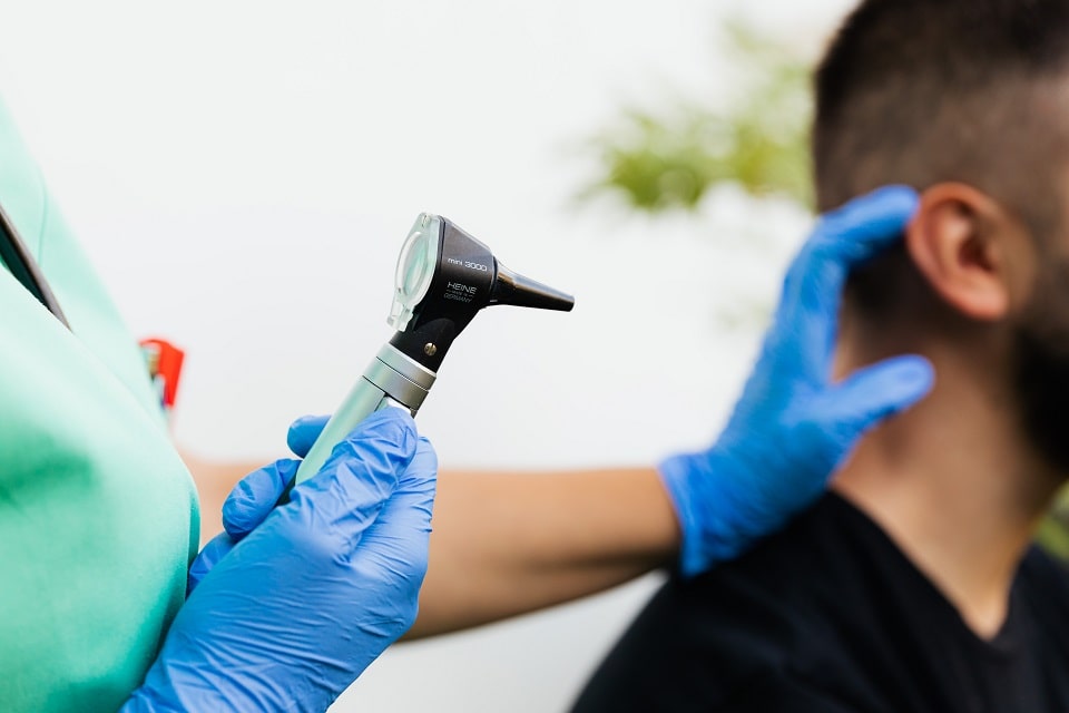 Médecin ORL avec otoscope pour examen d'une névrite vestibulaire