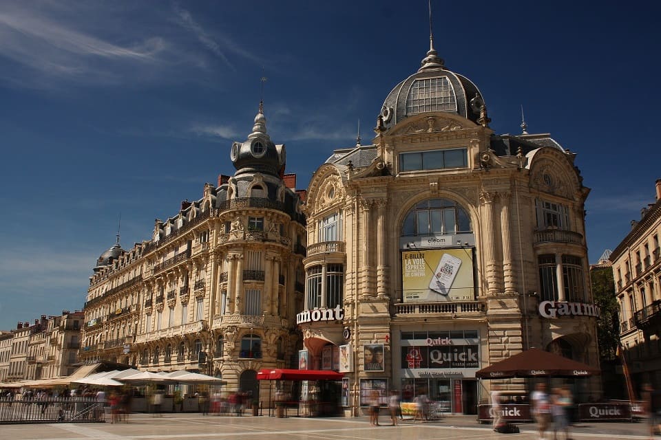 Place de la Comédie à Montpellier avec architecture historique et ciel bleu clair.