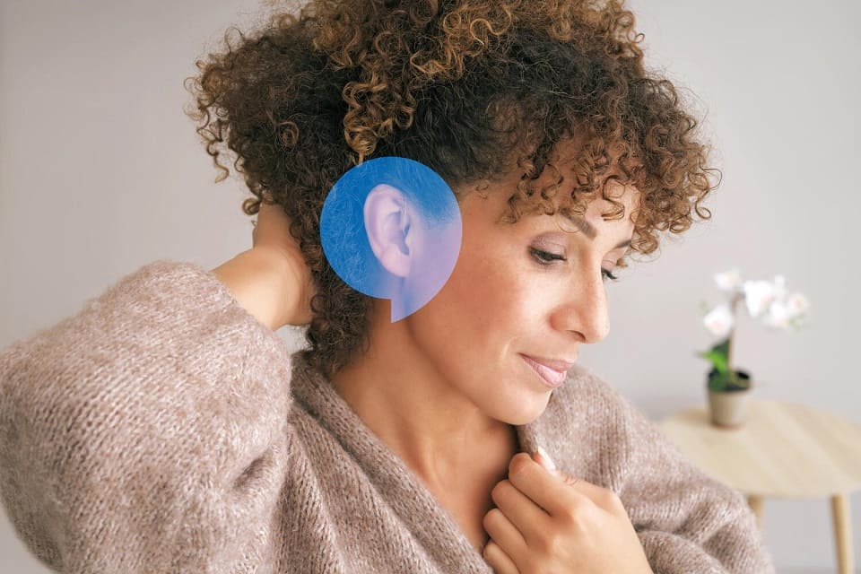 Personne portant des appareils auditifs intelligents Audika Extra dans une ambiance confortable.