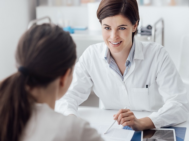 Spécialiste de l'audition expliquant des options de traitement à une patiente concernant la perte auditive