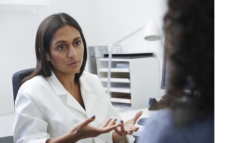 Audioprothésiste expliquant les causes et solutions possibles des hallucinations auditives à un patient.